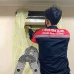 Foto teknisi Refcon Polar Nusaindo sedang mencuci AC Indoor.